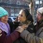 Cambridge, MA - 12/4/2016 - Sahida Akter (cq), left, whose family lost everything in the fire, is comforted by unidentified women. Her family, from Bangladesh, lived in the building in the backgrond. Crews continue working the scene of a 10-alarm fire in Cambridge, the morning after it erupted on Berkshire Street. Photo by Pat Greenhouse/Globe Staff Topic: 05cambridgefire Reporter: Nicole Fleming 