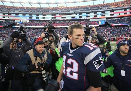 Quarterback Tom Brady surrounded by photographers after the Patriots defeated the Rams, 26-10, at Gillette Stadium. 
