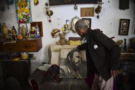 TOPSHOT - A man shows a poster of late Cuban revolutionary leader Fidel Castro at his home in Havana on November 29, 2016, as tributes to the former president are being held across the country. Castro died late November 25 in Havana at age 90. His ashes will be buried in the historic southeastern city of Santiago on December 4 after a four-day procession through the country. / AFP PHOTO / RONALDO SCHEMIDTRONALDO SCHEMIDT/AFP/Getty Images
