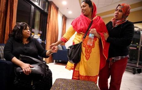 St. Patrick's Place residents Marcia Jones, left, and Sahida Akter, center, talked in the lobby at the Holiday Inn Express in Cambridge on Tuesday, while Akter's friend, Musammad Sadarbanu, comforted her.
