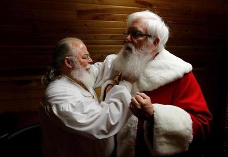 Santa Jim Hastings (R) from Durham, North Carolina, is helped into his suit by a fellow Santa prior to a visit from a group of children at the Santa House in Midland, Michigan, U.S. October 28, 2016. REUTERS/Christinne Muschi SEARCH 