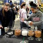 Emily Tripp, left, from Westport, Mass., and Jordan Hue, from Mashpee, made complimentary cups of hot chocolate at the cocoa bar at the South Shore Plaza. 