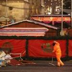BERLIN, GERMANY - DECEMBER 21: A worker collects remains from the wrecked Christmas market where two days before a man drove a heavy truck into the market in an apparent terrorist attack on December 21, 2016 in Berlin, Germany. So far 12 people are confirmed dead and 48 injured. Authorities initially arrested a Pakistani man whom they believed was the driver of the truck, though later released him and are now pursuing other leads. Among the dead are a Polish man with a gunshot wound who was found on the passenger seat of the truck. Police are investigating the possibility that the truck, which belongs to a Polish trucking company, was hijacked the morning of the attack. (Photo by Sean Gallup/Getty Images)