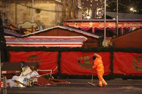 BERLIN, GERMANY - DECEMBER 21: A worker collects remains from the wrecked Christmas market where two days before a man drove a heavy truck into the market in an apparent terrorist attack on December 21, 2016 in Berlin, Germany. So far 12 people are confirmed dead and 48 injured. Authorities initially arrested a Pakistani man whom they believed was the driver of the truck, though later released him and are now pursuing other leads. Among the dead are a Polish man with a gunshot wound who was found on the passenger seat of the truck. Police are investigating the possibility that the truck, which belongs to a Polish trucking company, was hijacked the morning of the attack. (Photo by Sean Gallup/Getty Images)
