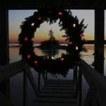A Christmas wreath decorated with lights hung at the end of a dock in Maine. 