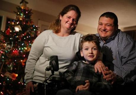 Seven-year-old Matthew Davidopoulos, who has spinal muscular atrophy, posed for a portrait with his parents Courtney and Paul at their home in Westford.
