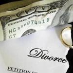 torn divorce decree and cash, with broken wedding ring