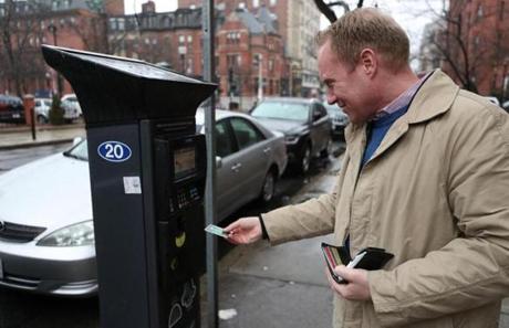 Paul Mahoney of Boston paid a parking meter on Newbury Street. 
