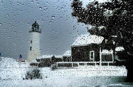 The Scituate Lighthouse was seeen through drops of melted snow on a car window. 
