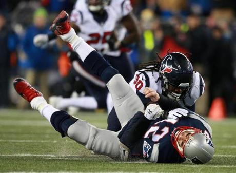 Foxborough, MA - 1-14-17 - Tom Brady is hit by Jadeveon Clowney after throwing a pass during second quarter action during AFC Divisional Playoff game - Gillette Stadium. Houston Texans @ New England Patriots. (Jim Davis/Globe staff)
