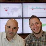 Apptopia executives Eliran Sapir (left) and Jonathan Kay. The monitors display crucial company data in real time.