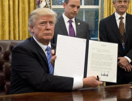 President Donald Trump held up the executive order withdrawing the US from the Trans-Pacific Partnership on Monday.
