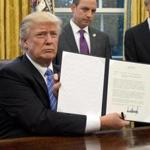 President Donald Trump held up the executive order withdrawing the US from the Trans-Pacific Partnership on Monday.