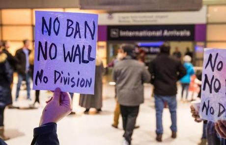 A protester held a sign that reads ?No Ban No Wall No Division? at Boston Logan Airport?s Terminal E on Saturday.

