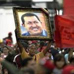 A supporter of Venezuelan President Nicolas Maduro holds a portrait of late Venezuelan President Hugo Chavez during a demonstration march to the Miraflores presidential palace in Caracas on April 7, 2016. Supporters of Venezuelan President Nicolas Maduro mobilized to ask him to block an amnesty law promoted by the opposition, and already approved in the opposition-controlled Parliament, but that still requires presidential approval. / AFP / JUAN BARRETO / JUAN BARRETO (Photo credit should read JUAN BARRETO/AFP/Getty Images)