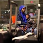Manchester, NH - February 02, 2017: Vanisi Vzamukunda comforts her sleepy daughter Sarah, 7, while waiting for their baggage at the Manchester?Boston Regional Airport in Manchester, NH on February 02, 2017. Members of the International Institute of New England - Lowell greeted the Congolese of seven and escorted them to their new home. . The family is originally from the Democratic Republic of the Congo but spent time in Uganda before coming to the United States. (Refugee organizations managed to get one last batch of refugees into the US by arguing that they were already 