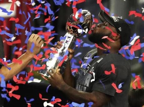 Houston, Tx-February 5, 2017-Stan Grossfeld/Globe Staff- Loid 8.3.1481249206 Super Bowl- Patriots vs Falcons- Patriots James White, who scored the OT touchdown to win Super Bowl 51 again takes the handoff from Tom Brady but this time to kiss the Vince Lombardi trophy.
