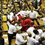 Economic Freedom Fighters in red are forcibly removed from parliament in Cape Town, South Africa, Thursday, Feb. 9, 2017. Parliament descended into chaos with opposition lawmakers denouncing President Jacob Zuma as a 