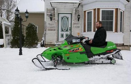 Jason Thomas took a break after riding his snowmobile in Brookfield.
