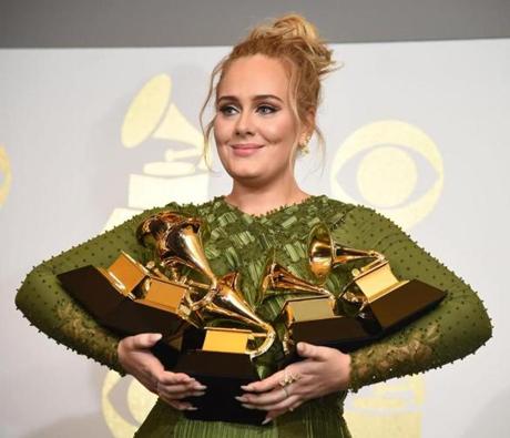 Adele posed with the five Grammys she won.
