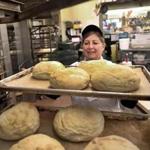 Bakery manager Cathy Curry loaded bread on to trays while working at the Roche Bros. store in Quincy.