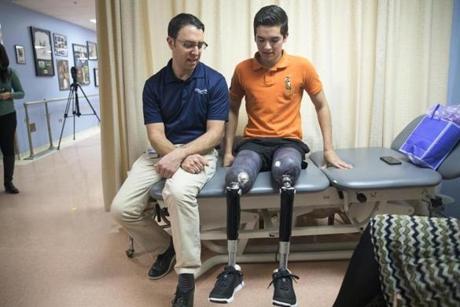 Earlier this month, prosthetist David Rotter, left, of Scheck & Siress, coached Vidal Lopez before he took a walk down the hallway in his new prosthetic legs.
