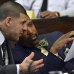Aaron Hernandez, left, and defense attorney Ronald Sullivan go over paperwork during motion hearings prior to Hernandez's double murder trial in Boston, Monday, Feb. 13, 2017. (Chris Christo/The Boston Herald via AP, Pool)