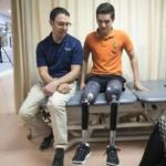 Earlier this month, prosthetist David Rotter (left) of Scheck & Siress coached Vidal Lopez before he took a walk down the hallway in his new prosthetic legs.