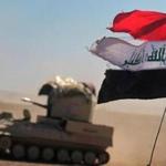An Iraqi flag fluttered as an armored vehicle with paramilitary fighters made its way south of Mosul Sunday.