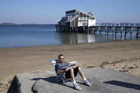 Rick La Civita of Randolph took advantage of the warm weather to kick back and read a newspaper at Wollaston Beach. 
