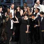 Producer Adele Romanski (center) with writer/director Barry Jenkins, and other cast and crew members accepted the best picture Oscar.