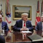 President Donald Trump, flanked by Independence Blue Cross CEO Daniel J. Hilferty, left, and Blue Cross and Blue Shield of North Carolina CEO Brad Wilson, speaks during a meeting with health insurance company executives in the Roosevelt Room of the White House in Washington, Monday, Feb. 27, 2017. (AP Photo/Pablo Martinez Monsivais)