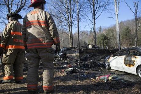 Firefighters examined the charred rubble of a two-story home in Warwick, Mass., that was destroyed by fire.

