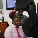 Roxbury, MA -- 3/9/2017 - Tito Jackson (L) does a quick workout with Cleon James, the owner of Top Notch Barber Shop on Washington Street in Roxbury as he drops in for a hair cut. () Topic: 11Tito Reporter: 