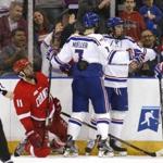 Cornell's Eric Freschi (11) reacts as UMass Lowell's Tyler Mueller and Ryan Dmowski celebrate a goal during the second period of an NCAA regional men's college hockey tournament game, Saturday, March 25, 2017 in Manchester, N.H. (AP Photo/Mary Schwalm)