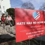 Jason and Elizabeth DelPorto with their anti-hate sign in their Watertown front yard. 