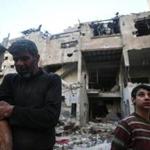 An man and his son stood in front of their destroyed house in Douma, Syria, on Friday.