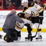 OTTAWA, ON - APRIL 12: Colin Miller #6 of the Boston Bruins is helped by teammate John-Michael Liles #26 and by the team trainer after bein tripped by Mark Borowiecki (not shown) of the Ottawa Senators in the second period in Game One of the Eastern Conference First Round during the 2017 NHL Stanley Cup Playoffs at Canadian Tire Centre on April 12, 2017 in Ottawa, Ontario, Canada. (Photo by Jana Chytilova/Freestyle Photography/Getty Images)