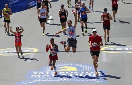 slider Boston, Massachusetts -- 4/17/2017 - Yuichiro Hidaka of Laramie, Wyoming leaps in the air before crossing the finish line of the 121st Boston Marathon. (Jessica Rinaldi/Globe Staff) Topic: Marathonpics Reporter: 
