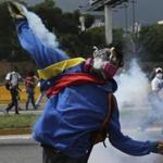 A demonstrator returns a canister of tear gas towards security forces during anti-government protests in Caracas, Venezuela, Wednesday, April 19, 2017. Tens of thousands of opponents of President Nicolas Maduro flooded the streets of Caracas in what's been dubbed the 