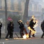 A French police officer was engulfed in flames as forces faced protesters during a May Day march in Paris. 
