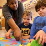 Worcester, MA- April 25, 2017: Teacher Latonya Hazard work on puzzles with students (left to right) Lilyana Waire (cq) , 2, Jordan Conrad (cq) 2, Caiden Groccia (cq), 2, and Joshua Davis (cq) 2, at the Guild of St. Agnes in Worcester, MA on April 25, 2017. The Guild of St. Agnes is an early education and care agency that relies on state subsidies for 95% of their students according to director Gloria Johnson. The availability of state-subsidized child care has been narrowing, and growing more separate from private daycare, as fewer providers accept low-income students. (Globe staff photo / Craig F. Walker) section: business reporter: