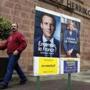 A man walked near election campaign posters for French presidential candidates.
