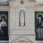 The pictures of Jacinta, left, and Francisco Marto, hang on the facade of the Sanctuary of Our Lady of Fatima, Saturday, May 13, 2017, in Fatima, Portugal. Pope Francis urged Catholics on Friday to 