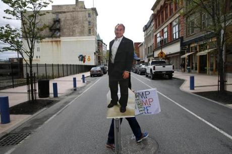 Bill Trommer, of Leeds, Maine, carried a poster of Representative Bruce Poliquin at the end of a protest held outside of his office.  
