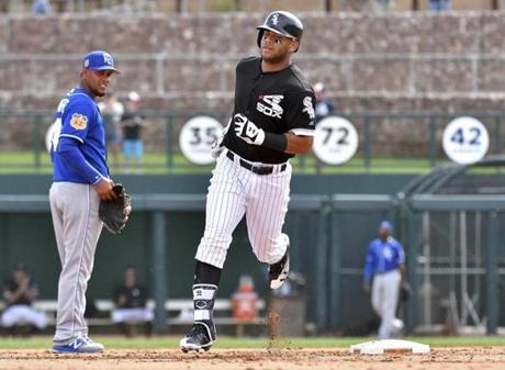 FILE - In this March 15, 2017, file photo, Chicago White Sox's Yoan Moncada rounds the bases past Kansas City Royals third baseman Ramon Torres on a two-run home run in the fifth inning of a spring training baseball game, in Glendale, Ariz. The rebuilding White Sox plan to go slow with Moncada, who just turned 21 in September. But he could bring his powerful swing and athleticism to Chicago?s starting lineup at some point this summer. (John Sleezer/The Kansas City Star via AP, File)
