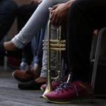 A Boston Arts Academy student sat with a trumpet between his feet at an event at Berklee College of Music.