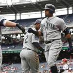 Seattle Mariners Nelson Cruz, right, celebrates with teammates, Kyle Seager, left, and Jean Segura (2) after hitting a three-run home run during the sixth inning of a baseball game against the Washington Nationals in Washington, Thursday, May 25, 2017. The Mariners won 4-2. (AP Photo/Manuel Balce Ceneta)