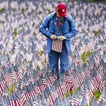 Boston, MA - 5/28/2017 - George Rohlfing, a volunteer for the Massachusetts Military Hero Fund, holds flags in the annual Memorial Day Flag Garden on Boston Common in Boston, MA, May 28, 2017. Over 37,000 flags are planted in the ground on the hill leading to the Soldiers and Sailors Monument to represent the military personnel from Massachusetts killed in combat since the Revolutionary War.(Keith Bedford/Globe Staff)