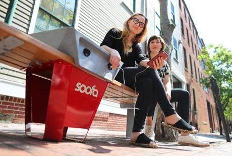Cambridge-05/17/2017- Soofa makes high-tech solar-powered information boards and park benches for charging smart phones. Sandra Richter(left) is the co-founder and CEO, as she plugs in her smartphone as company co-founder, Jutta Friedrichs sits beside her. JohnTlumacki/ The BostonGlobe (business)
